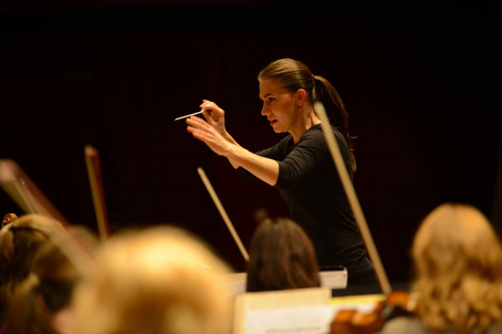 Marta Gardolińska conducts the orchestra with an intense expression